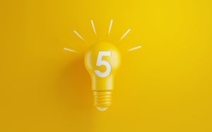 Light bulb on yellow background. Number five writes on the lightbulb. Horizontal composition with copy space. Creativity and innovation concept. software for a customer support team.