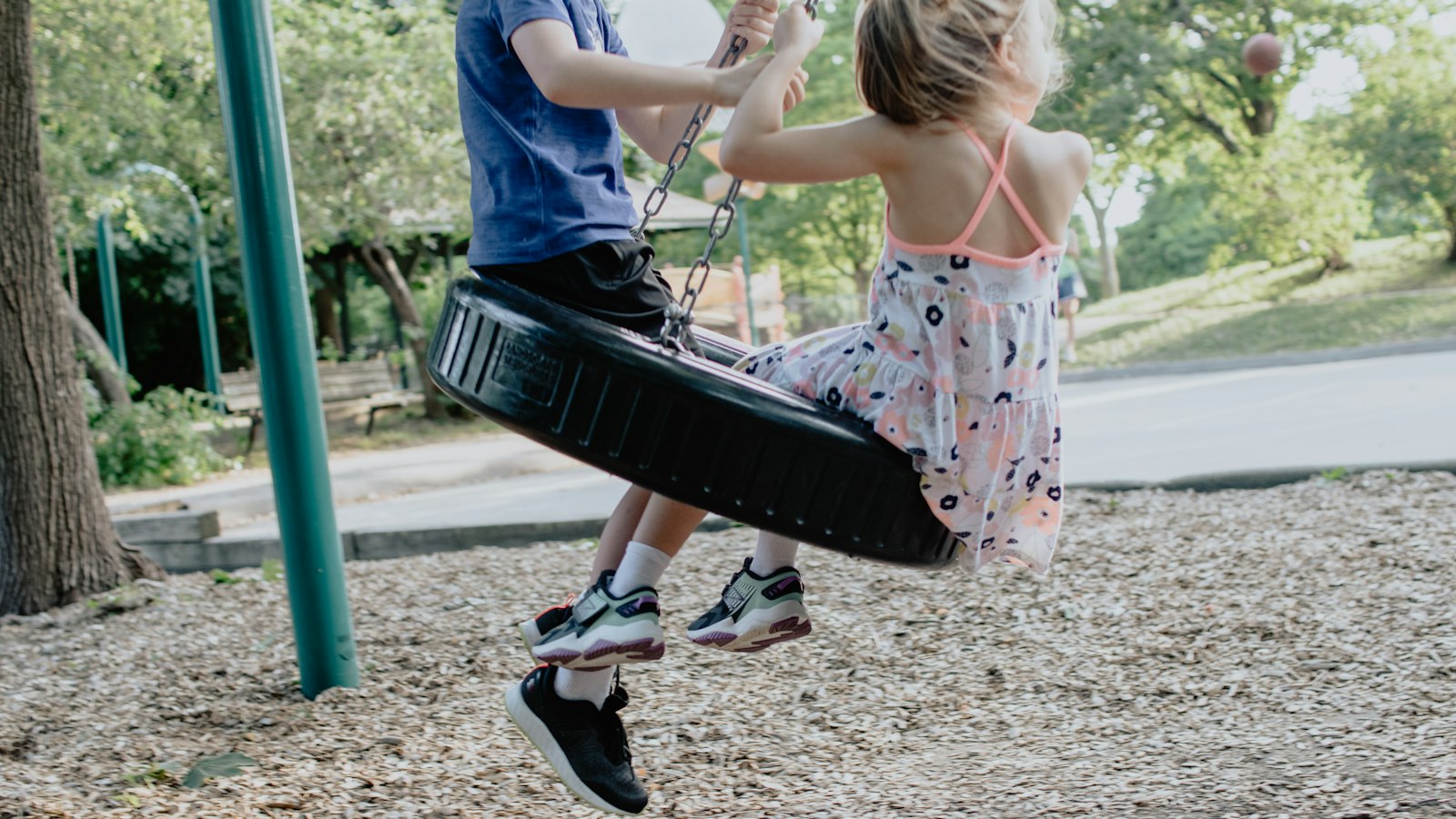 Kids on a tire swing at a park playdate
